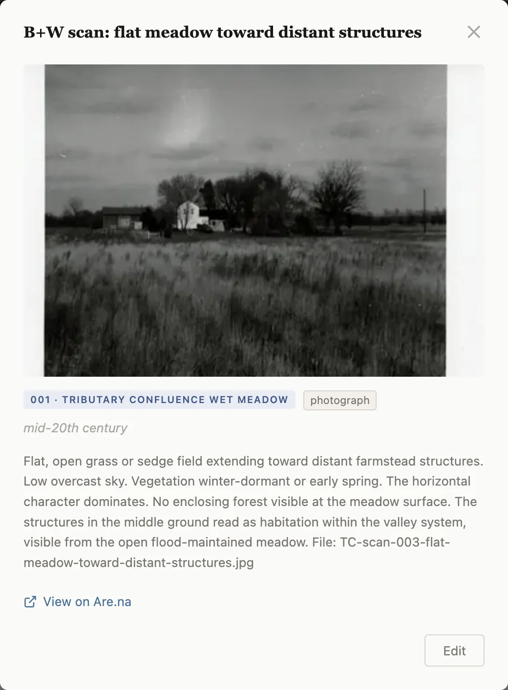 One artifact's detail view: a black-and-white photograph of a meadow and distant farm buildings, its location and type, an approximate date, and a written description.